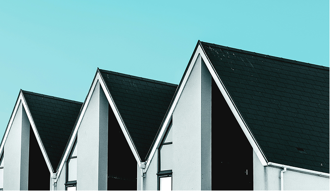 Modern white houses with peaked roofs against blue sky