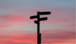 Directional signpost silhouette at sunset
